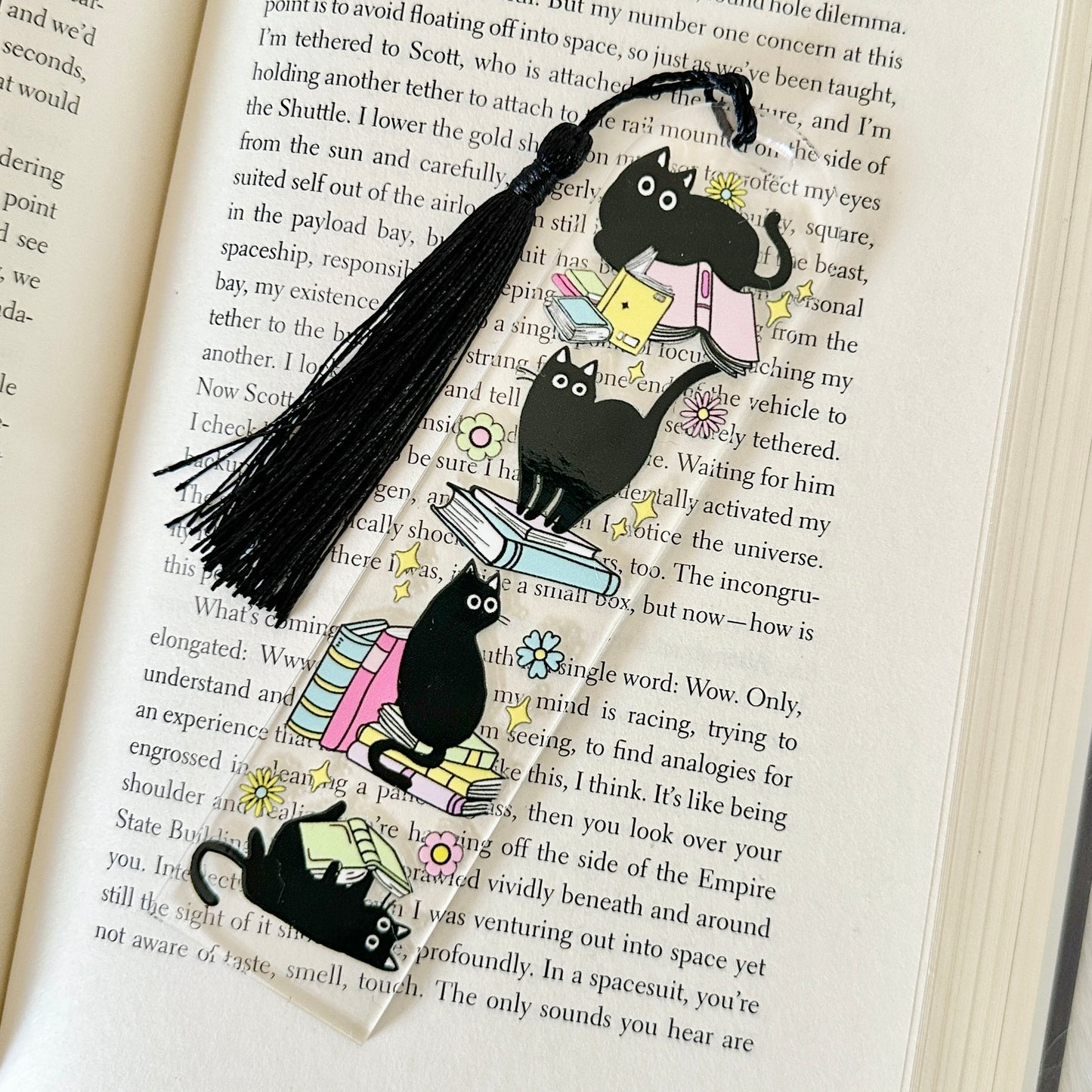 Bookmark with cat illustrations on an open book