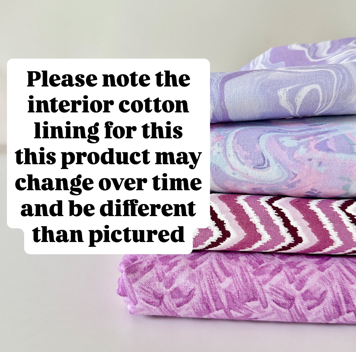 Stack of fabric with marbled patterns on a light gray background
