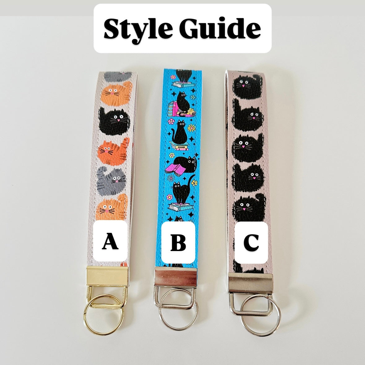 Three keychains with cat designs on a white background, labeled A, B, and C.