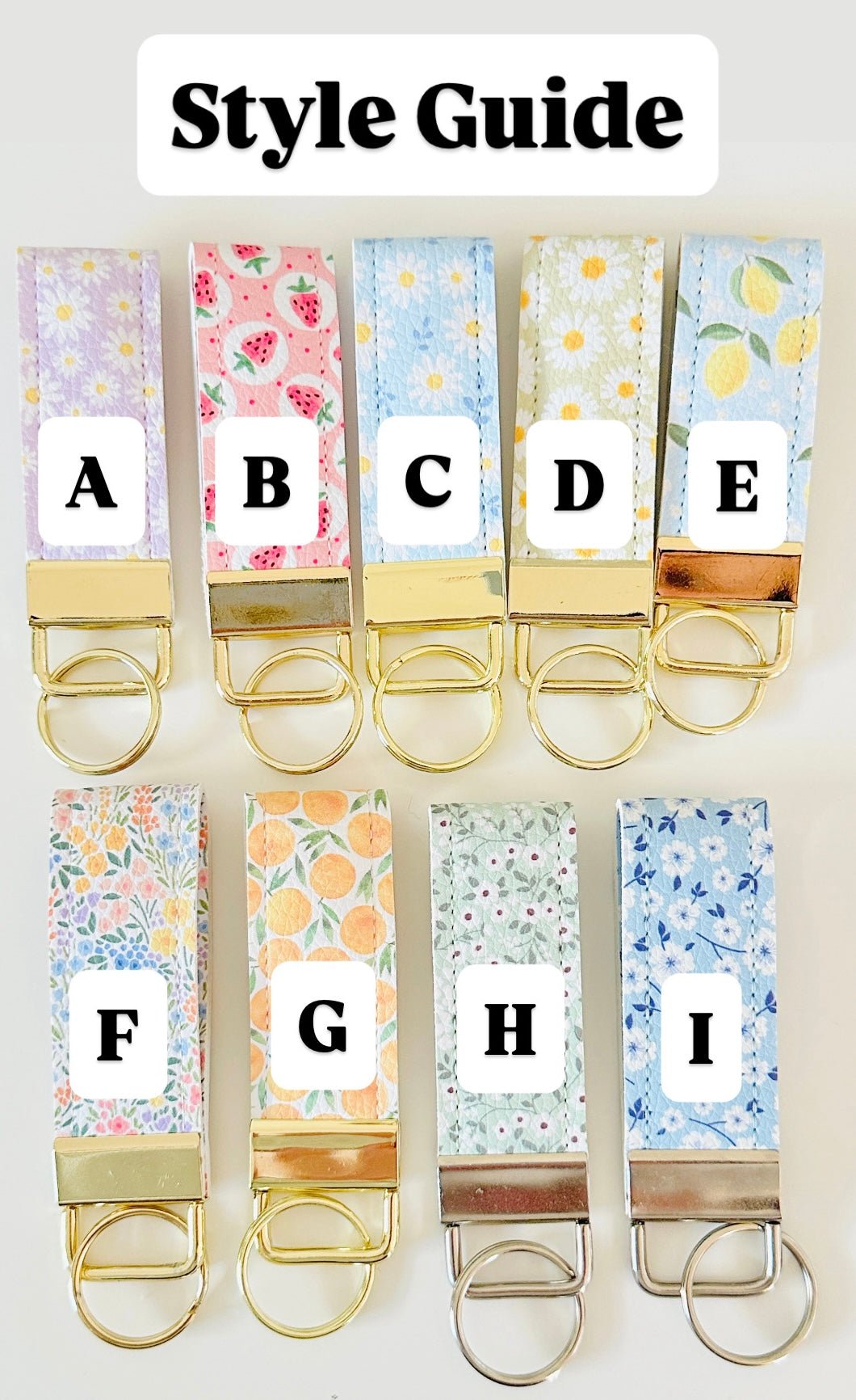 Set of colorful keychains with floral patterns and letter labels on a white background.
