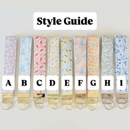 Set of keychains with floral patterns and letter labels on a white background