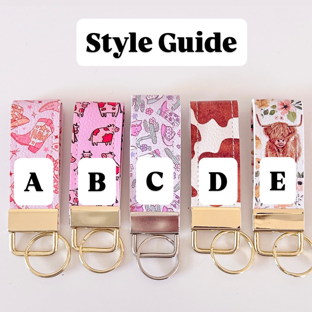Five keychains with different designs and letters on a white background