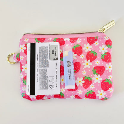 Pink strawberry coin purse with a daisy pattern on a white background