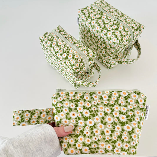 Set of three floral-patterned bags on a light gray background