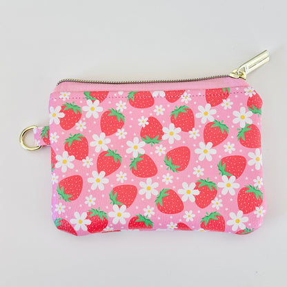 Pink strawberry coin purse with a daisy pattern on a white background