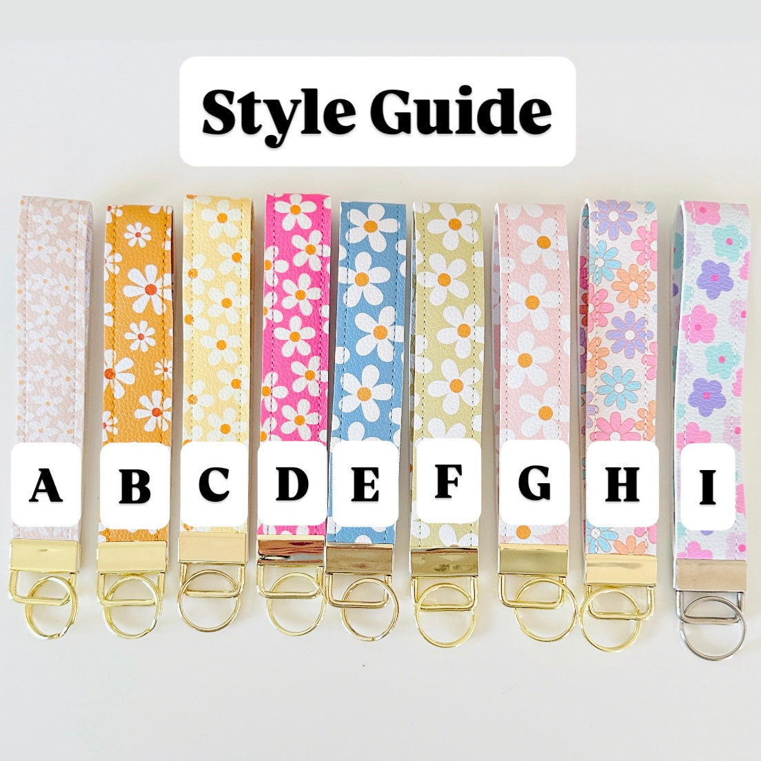 Set of floral patterned keychains with letter labels on a white background