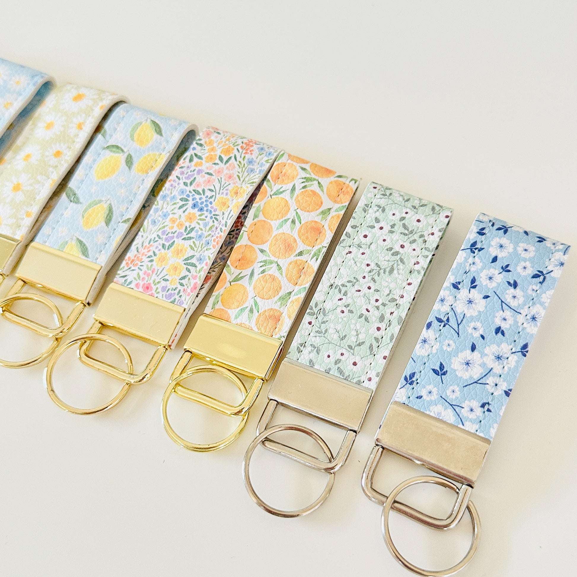 Set of keychains with floral and fruit patterns on a light background