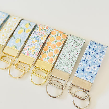 Set of keychains with floral and fruit patterns on a light background