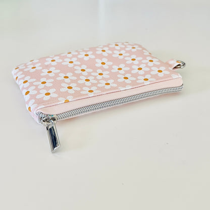 Floral-patterned coin purse with coins and cards on a light background