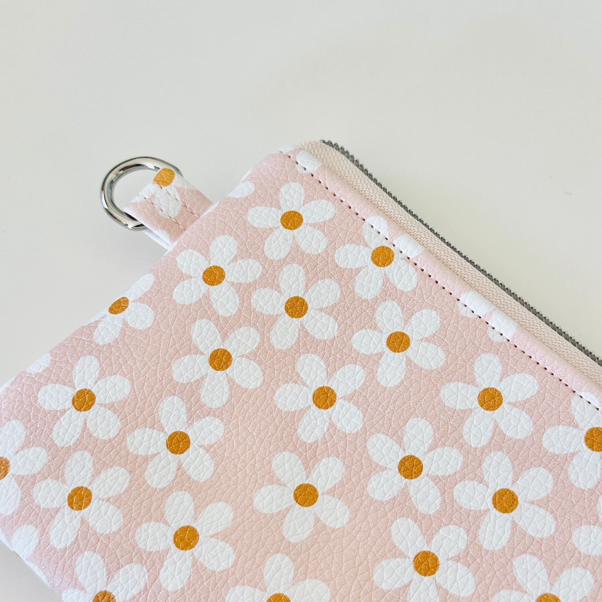 Floral-patterned coin purse with coins and cards on a light background