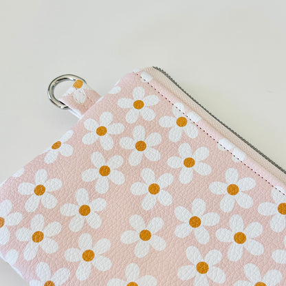 Floral-patterned coin purse with coins and cards on a light background