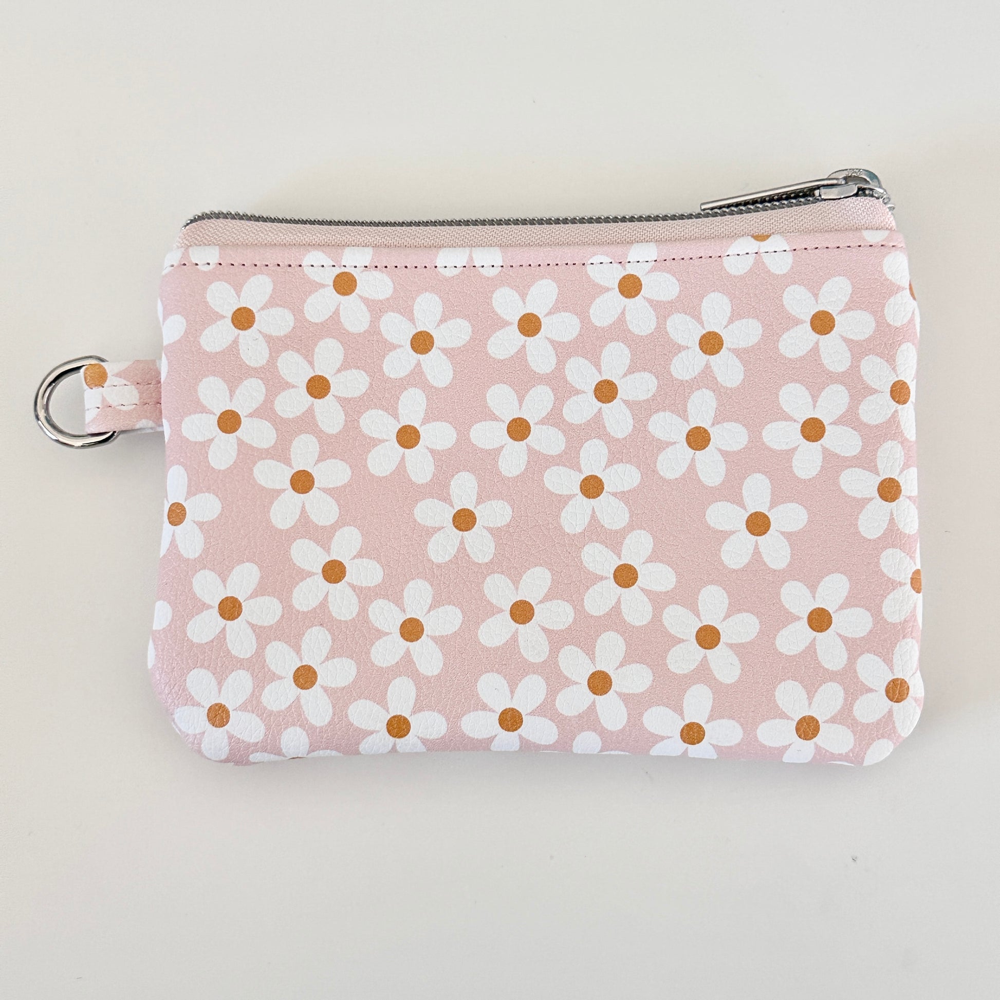 Floral-patterned coin purse with coins and cards on a light background