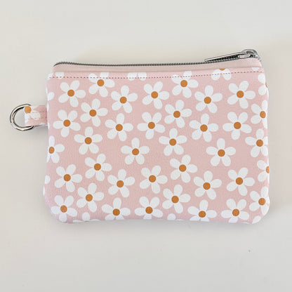 Floral-patterned coin purse with coins and cards on a light background
