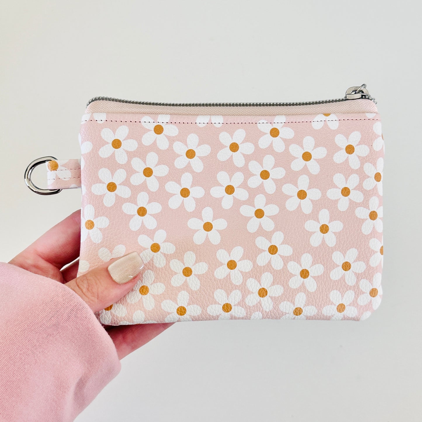 Floral-patterned coin purse with coins and cards on a light background