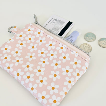 Floral-patterned coin purse with coins and cards on a light background