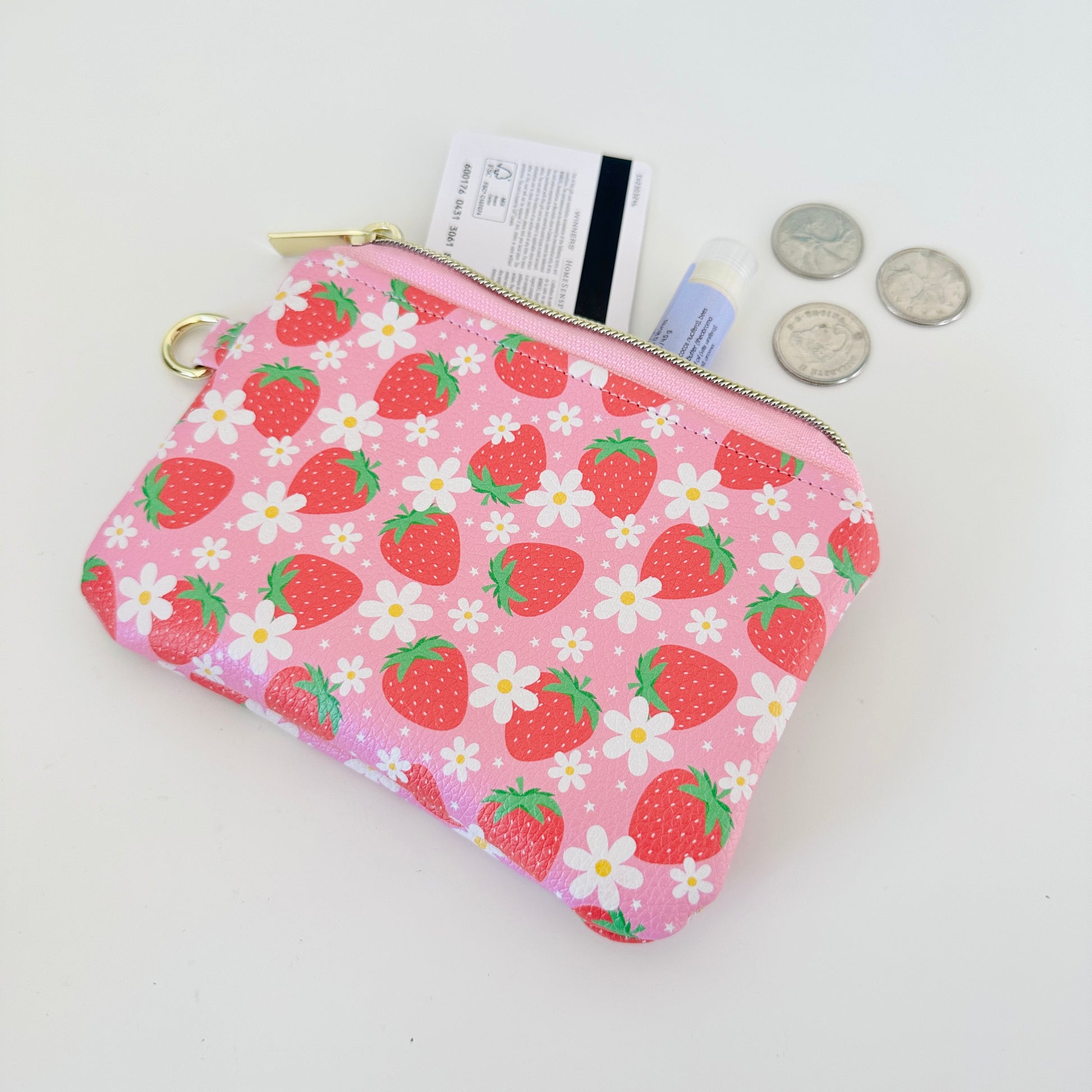 Pink strawberry coin purse with a daisy pattern on a white background