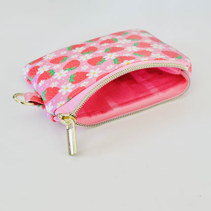 Pink strawberry coin purse with a daisy pattern on a white background