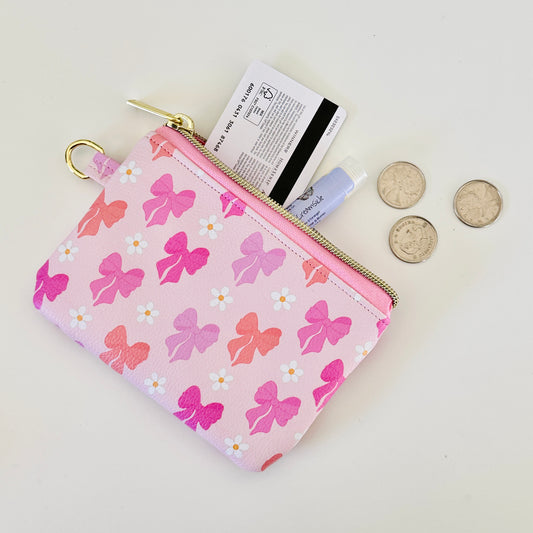 Pink coquette bow vegan leather coin purse with butterfly pattern on a white background