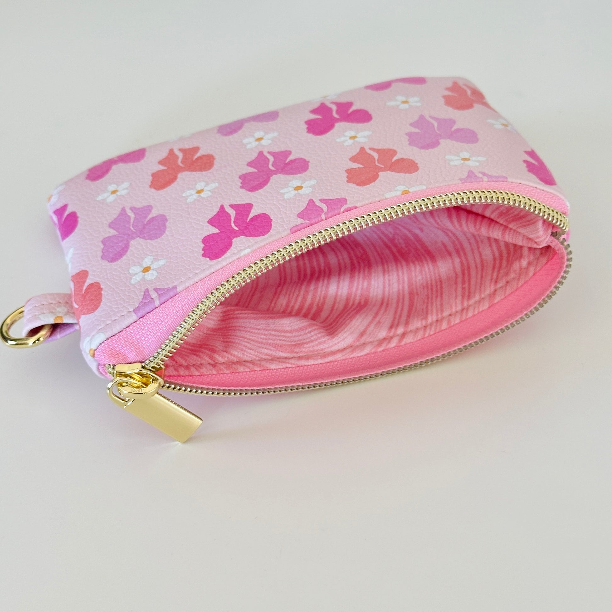 Pink coquette bow vegan leather coin purse with butterfly pattern on a white background