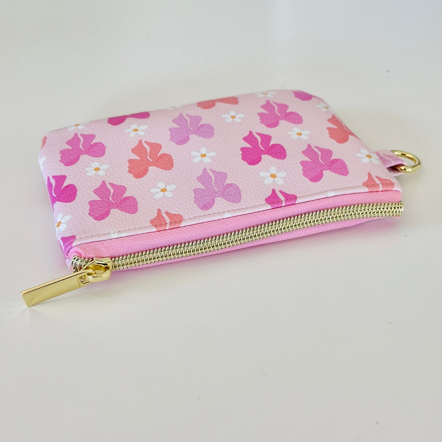 Pink coquette bow vegan leather coin purse with butterfly pattern on a white background