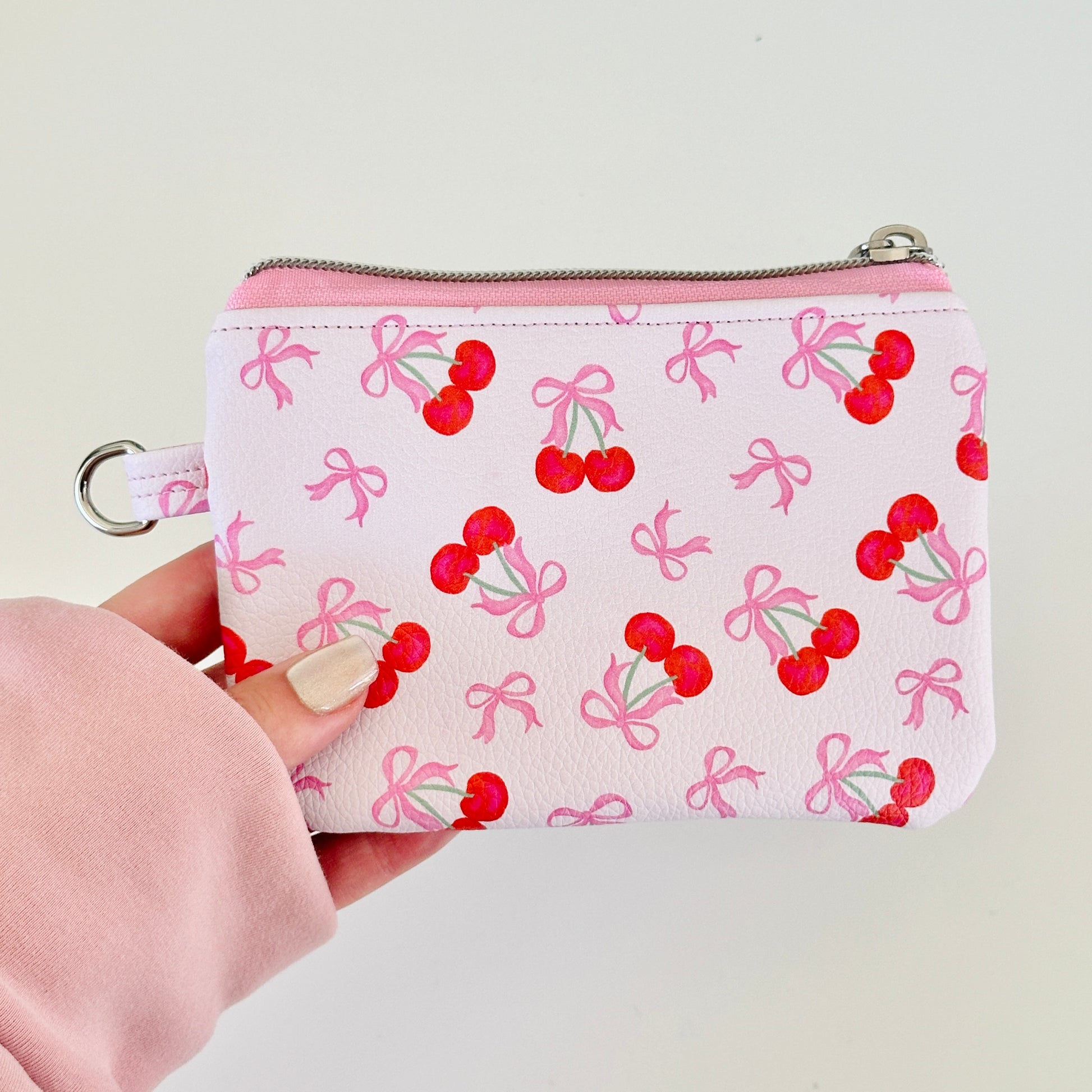 vegan leather coin purse with cherry bow pattern on a white background