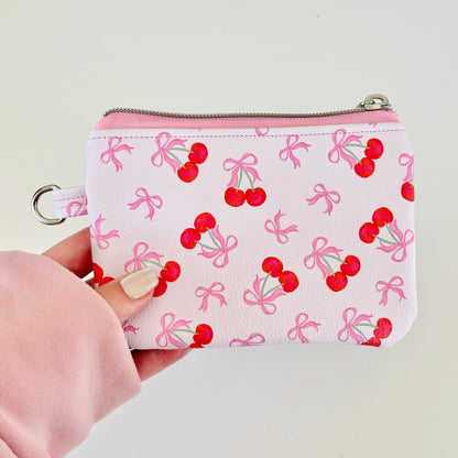 vegan leather coin purse with cherry bow pattern on a white background