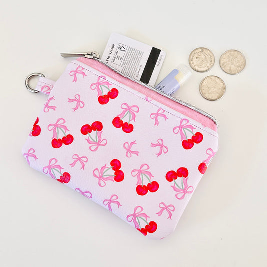 vegan leather coin purse with cherry bow pattern on a white background