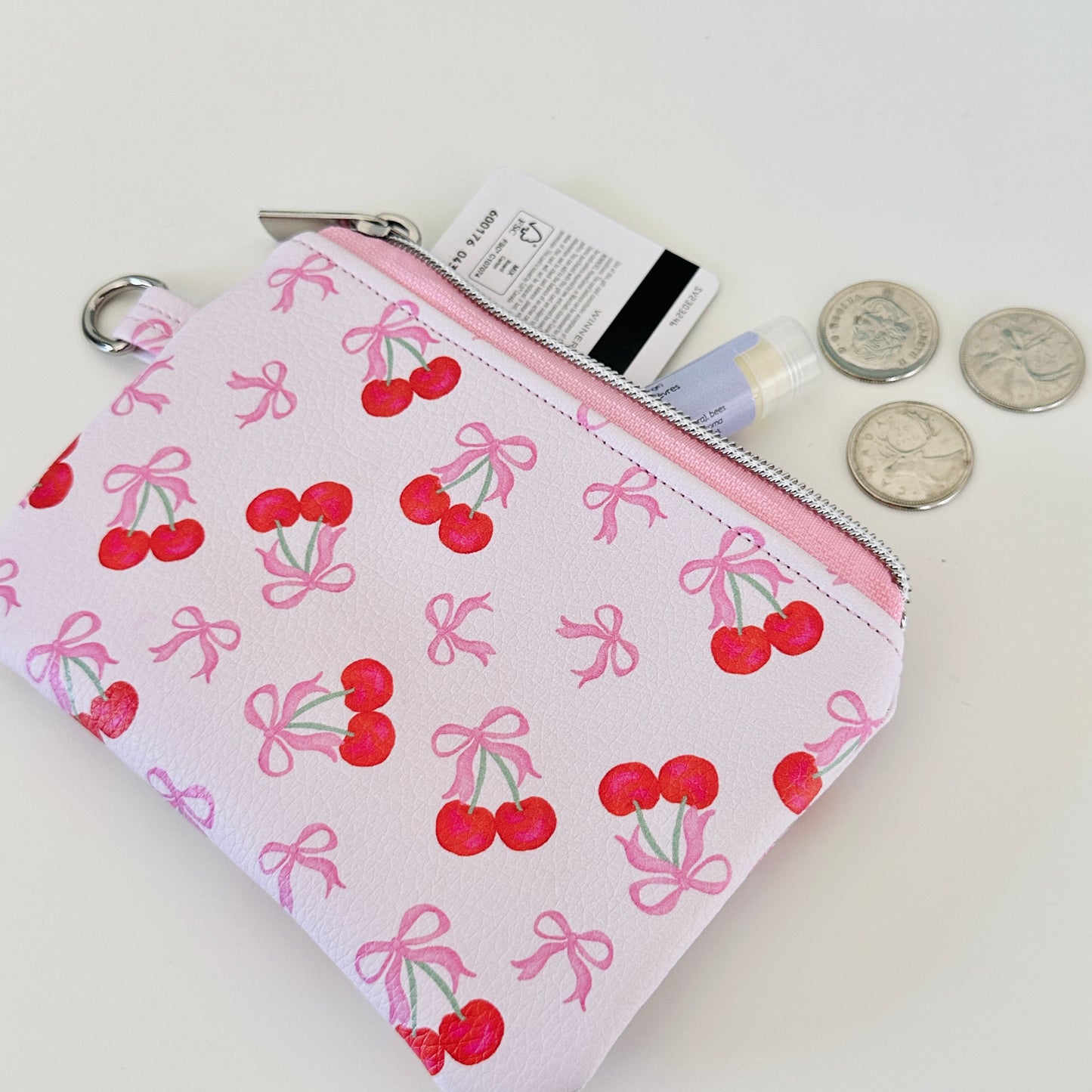 vegan leather coin purse with cherry bow pattern on a white background