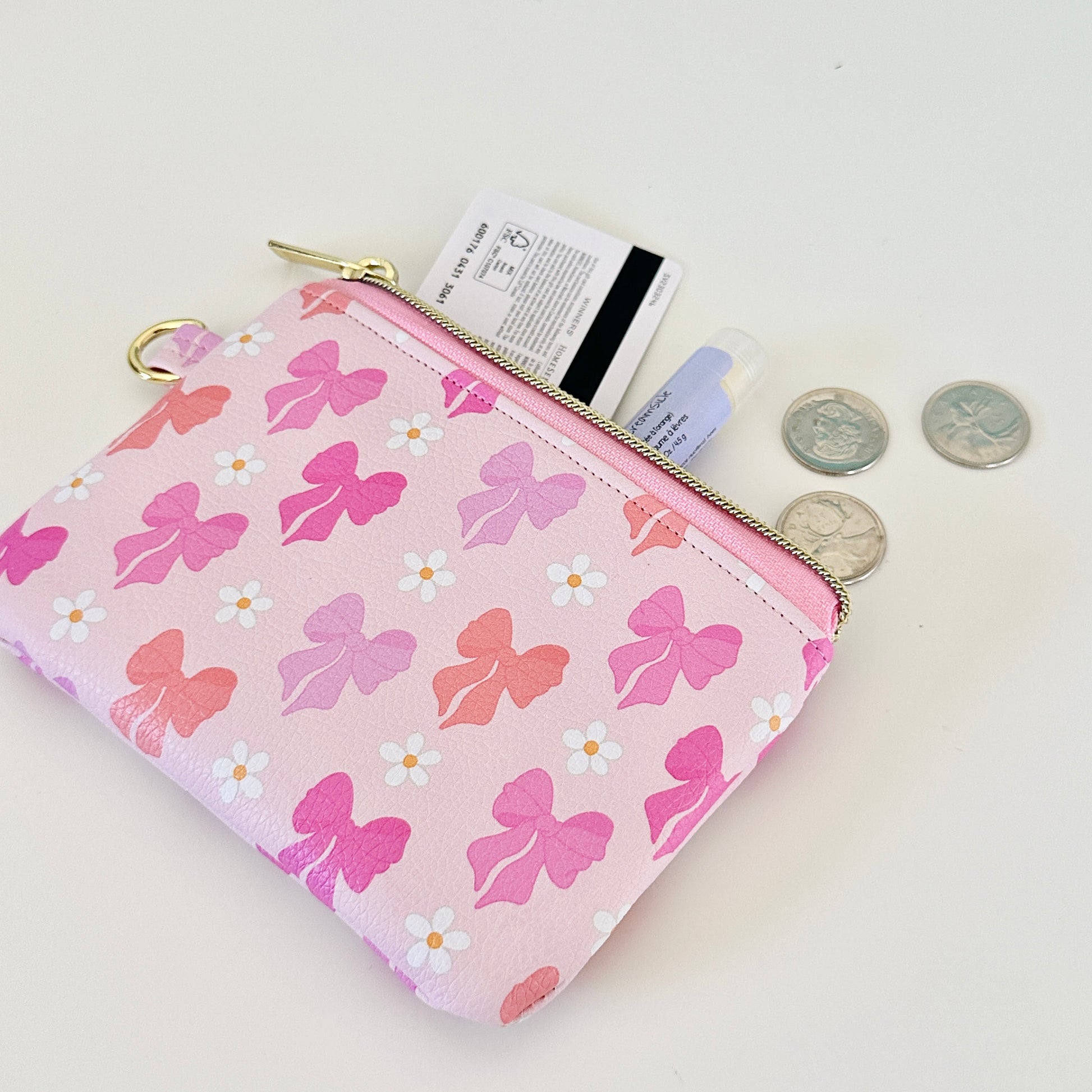 Pink coquette bow vegan leather coin purse with butterfly pattern on a white background