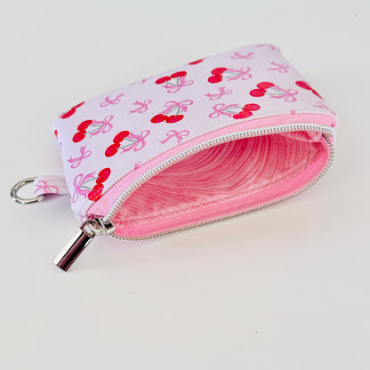 vegan leather coin purse with cherry bow pattern on a white background