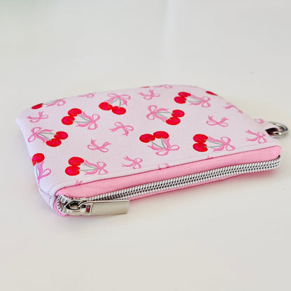 vegan leather coin purse with cherry bow pattern on a white background