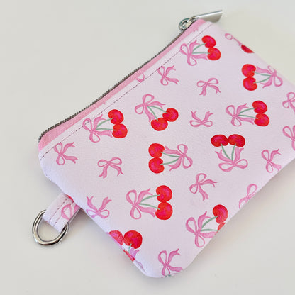 vegan leather coin purse with cherry bow pattern on a white background