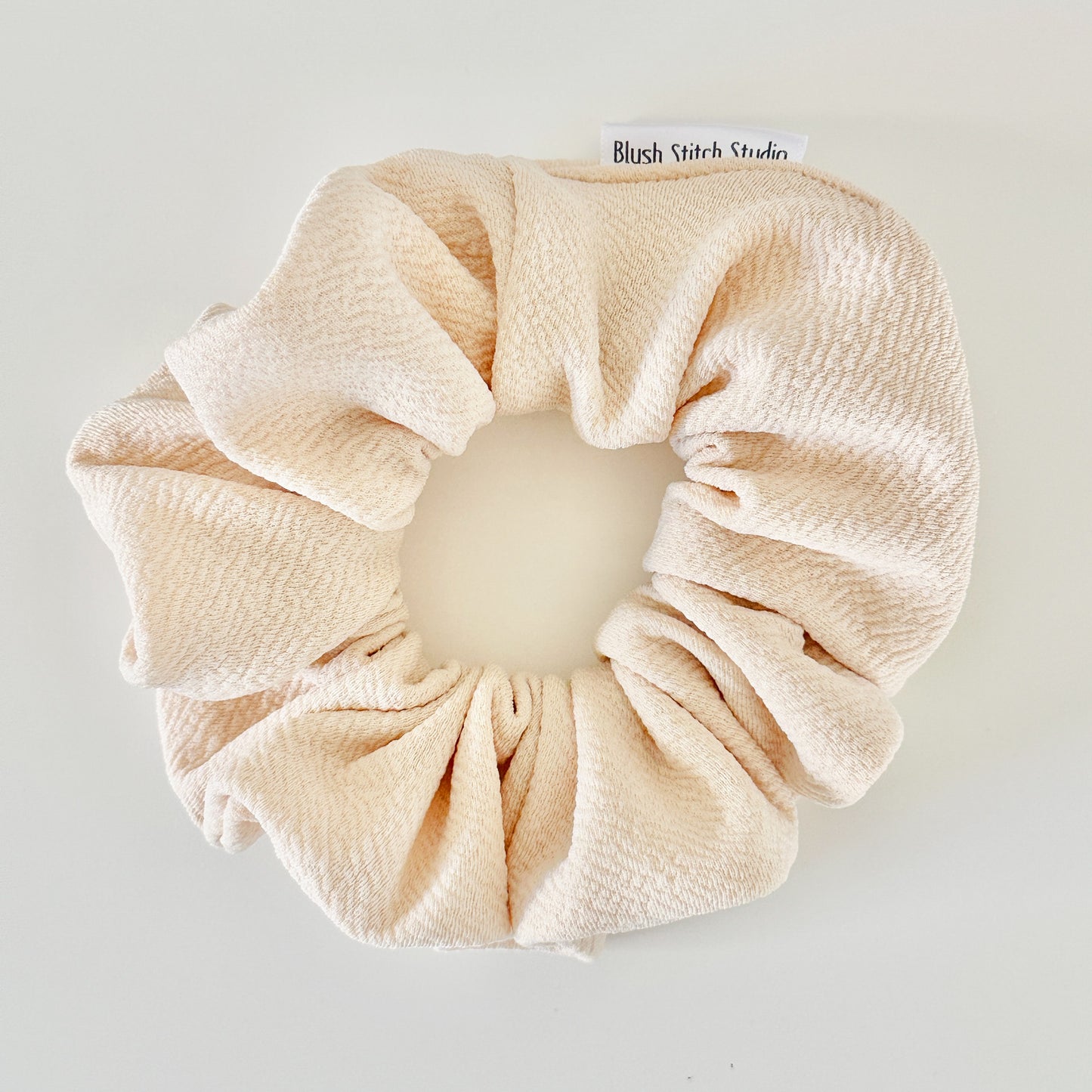ivory scrunchie on a light gray background with 'Blush Stitch Studio' branding.