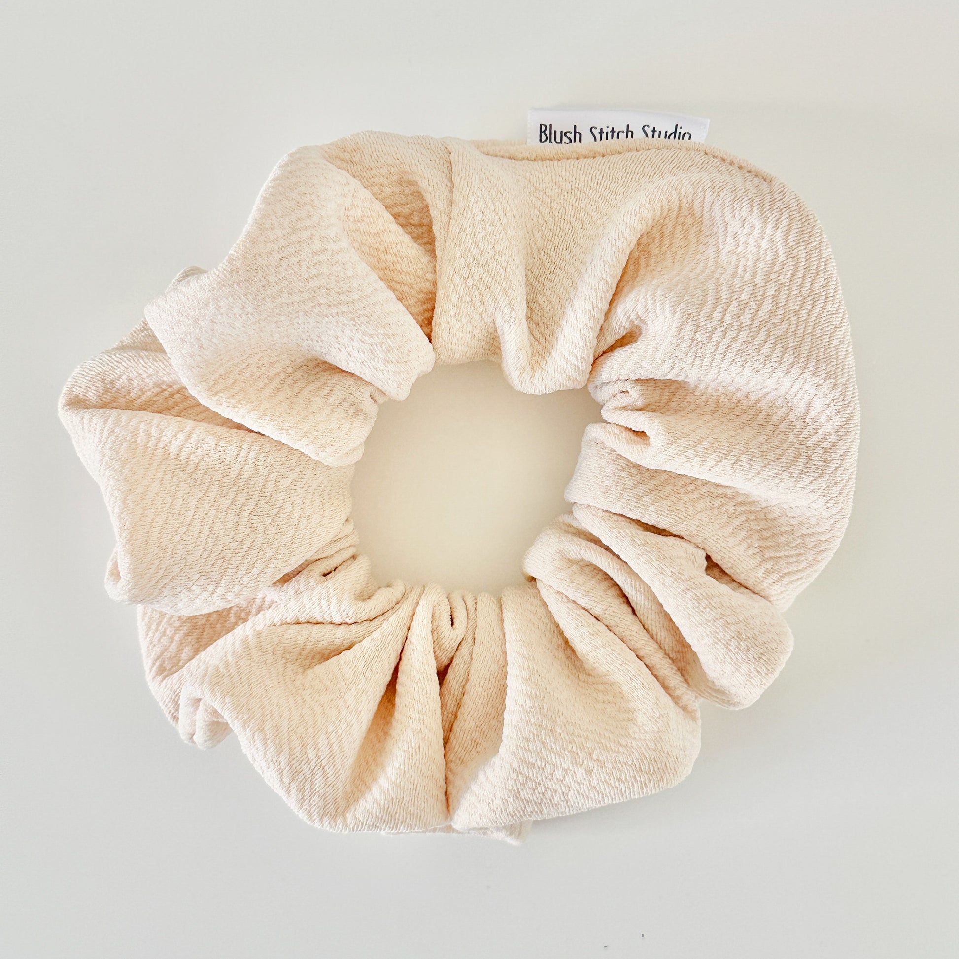 ivory scrunchie on a light gray background with 'Blush Stitch Studio' branding.