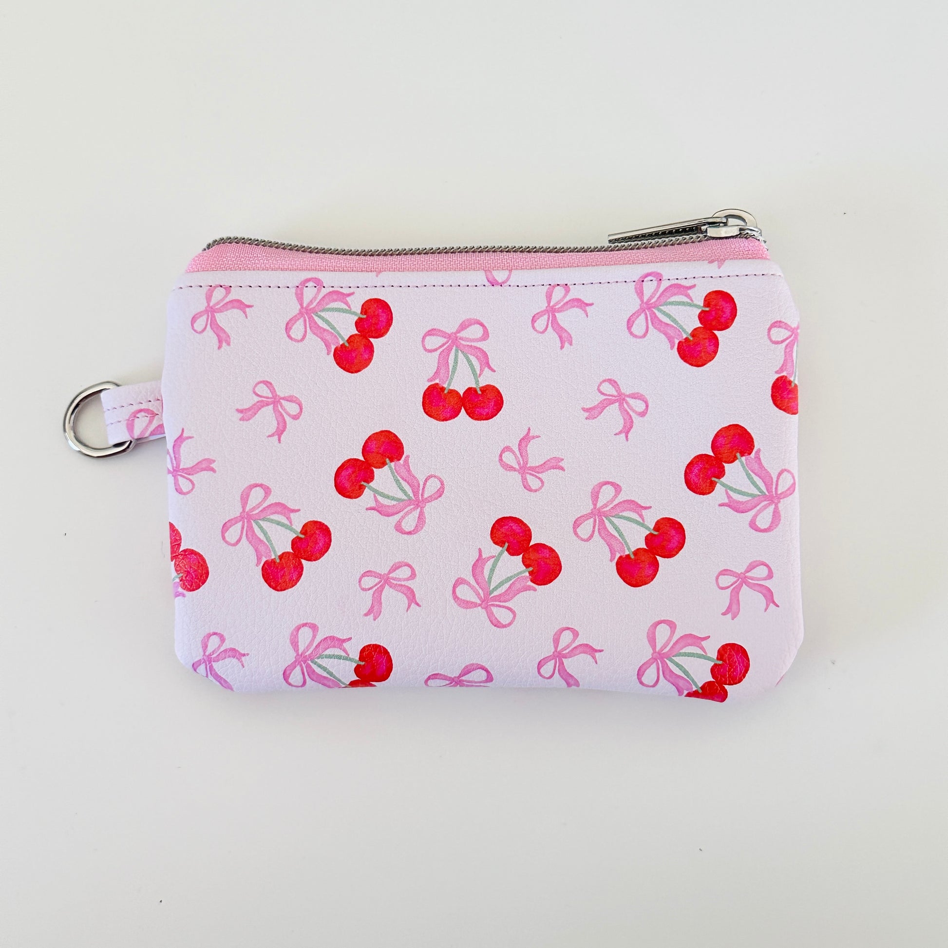 vegan leather coin purse with cherry bow pattern on a white background