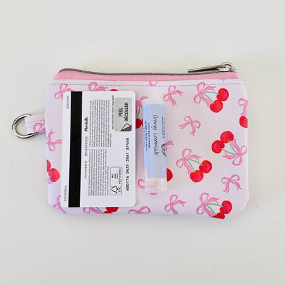 vegan leather coin purse with cherry bow pattern on a white background