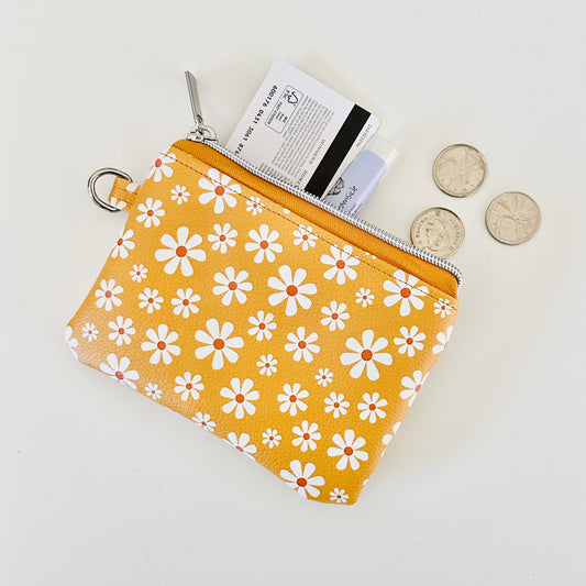 mustard Yellow coin purse with white floral pattern on a white background