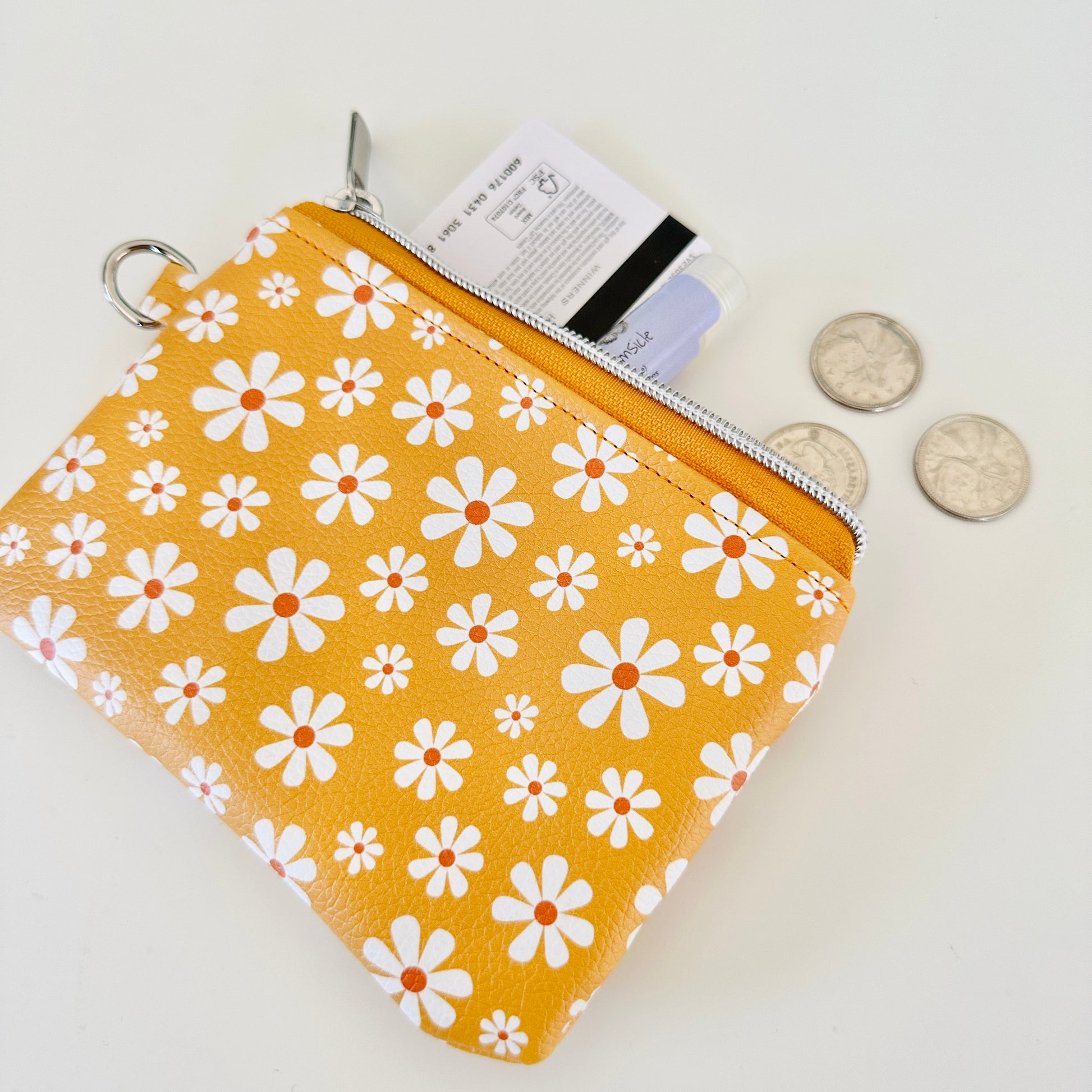 mustard Yellow coin purse with white floral pattern on a white background