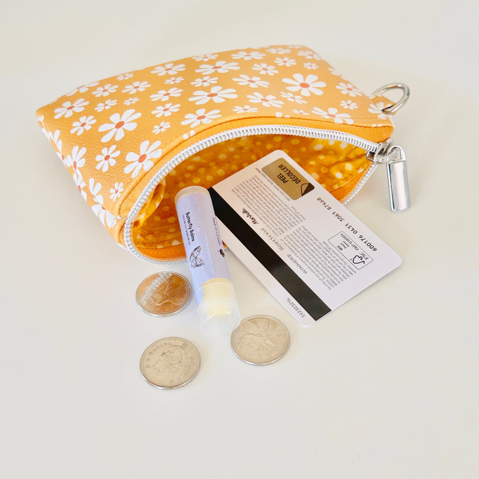mustard Yellow coin purse with white floral pattern on a white background