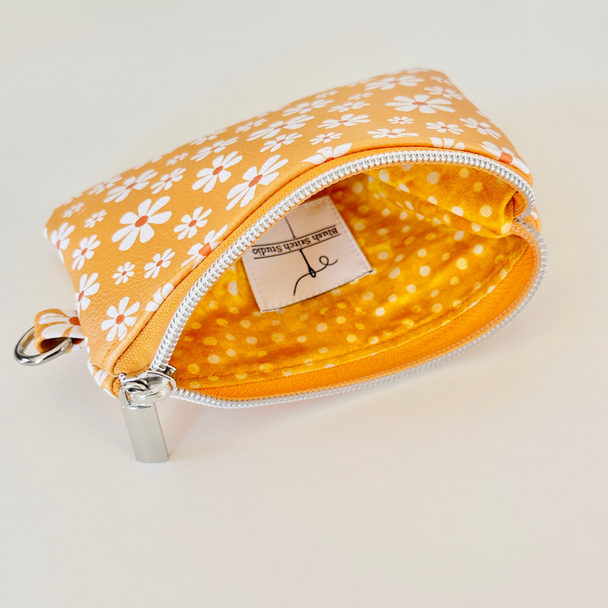 mustard Yellow coin purse with white floral pattern on a white background