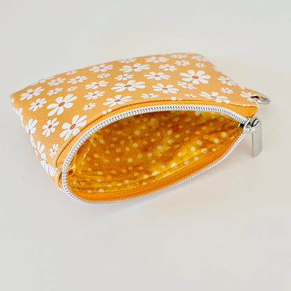 mustard Yellow coin purse with white floral pattern on a white background
