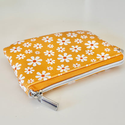 mustard Yellow coin purse with white floral pattern on a white background