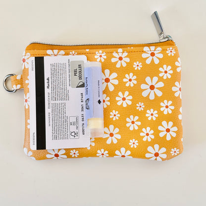 mustard Yellow coin purse with white floral pattern on a white background