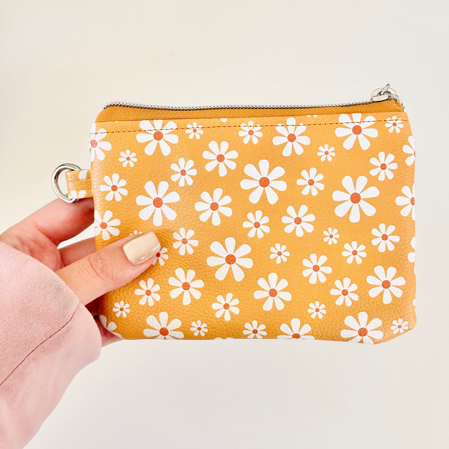 mustard Yellow coin purse with white floral pattern on a white background