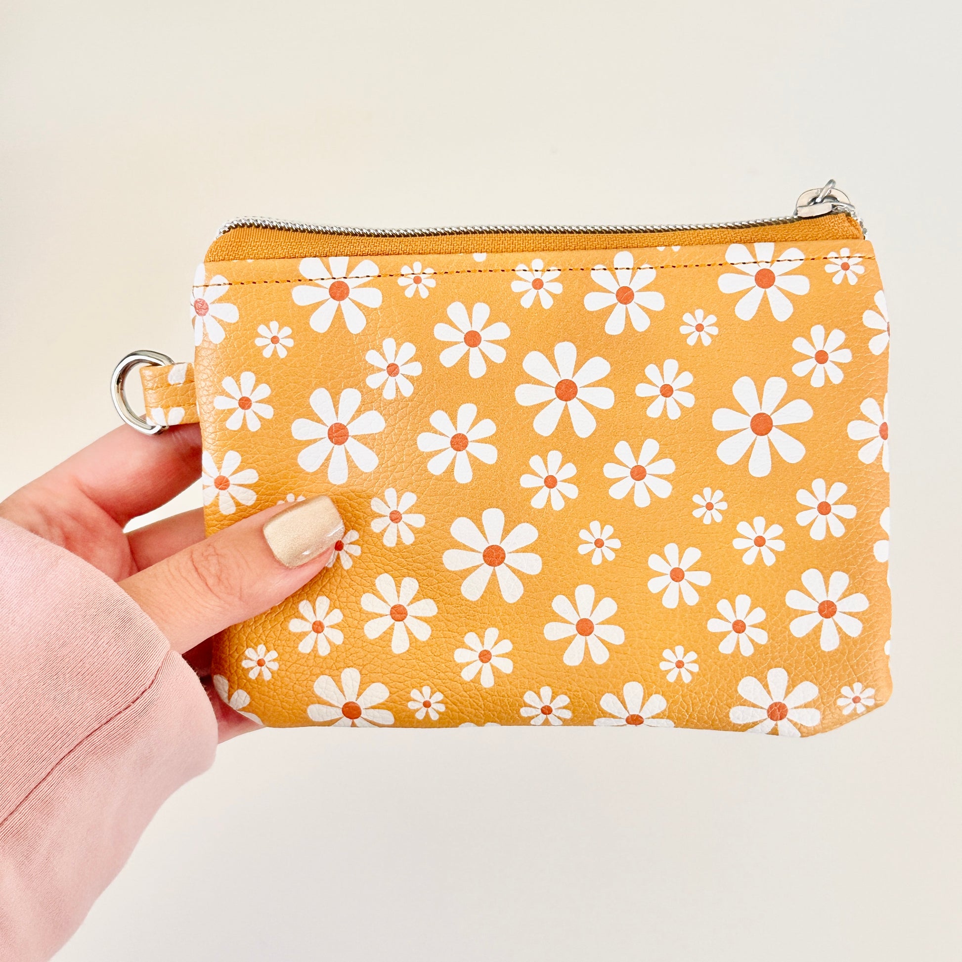 mustard Yellow coin purse with white floral pattern on a white background