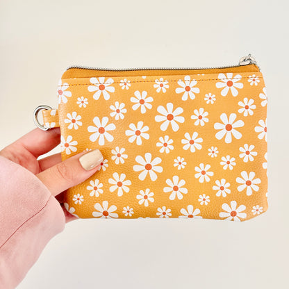 mustard Yellow coin purse with white floral pattern on a white background