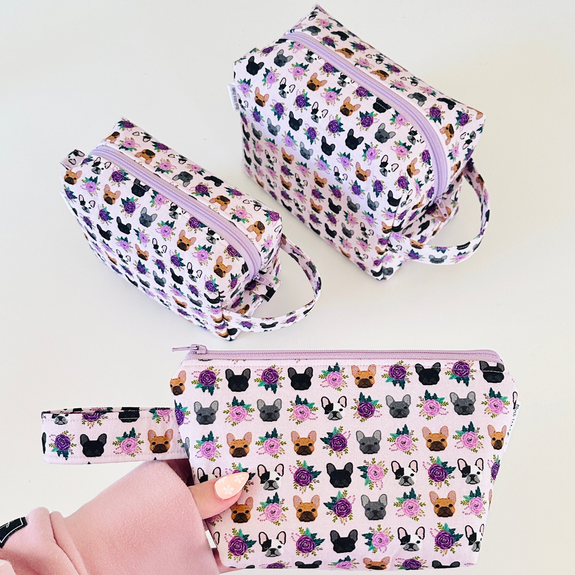 Set of three cosmetic bags with dog pattern on a white background