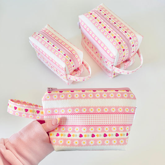 pink strawberry patterned makeup cosmetic bags on a white background