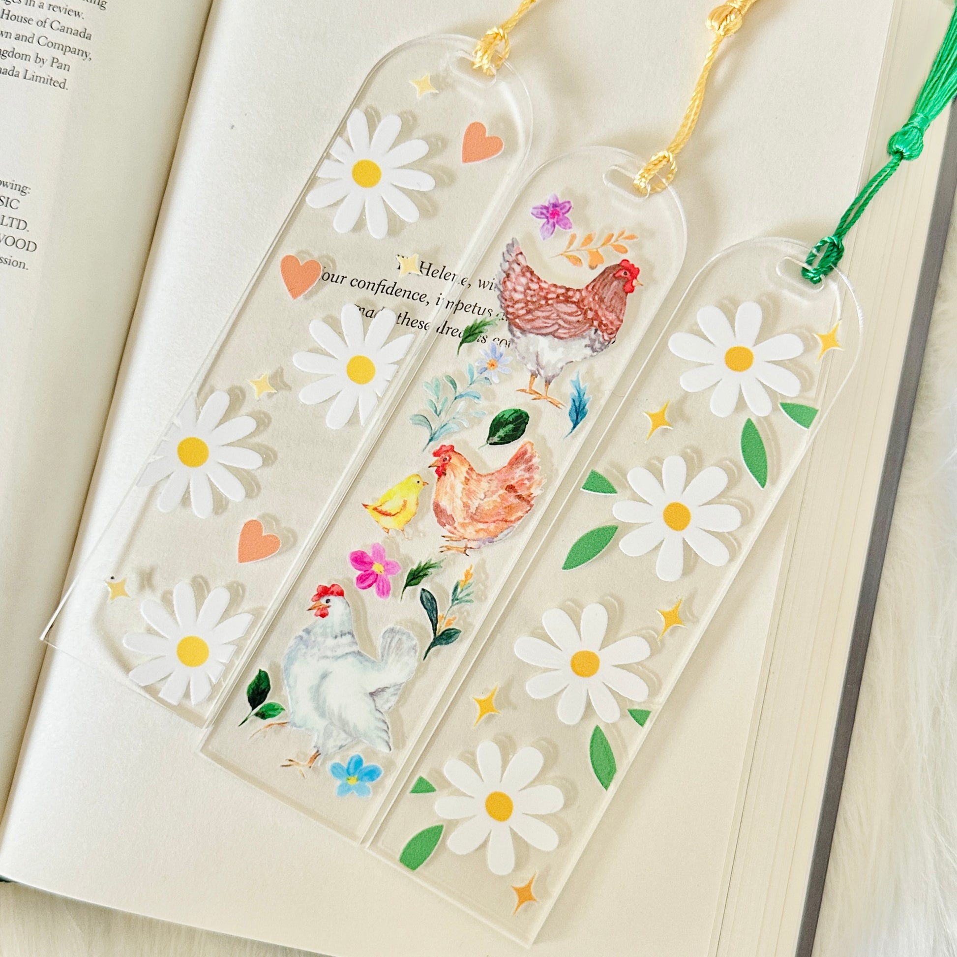 Decorative bookmarks with floral and chicken designs on an open book.