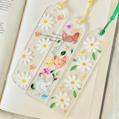 Decorative bookmarks with floral and chicken designs on an open book.